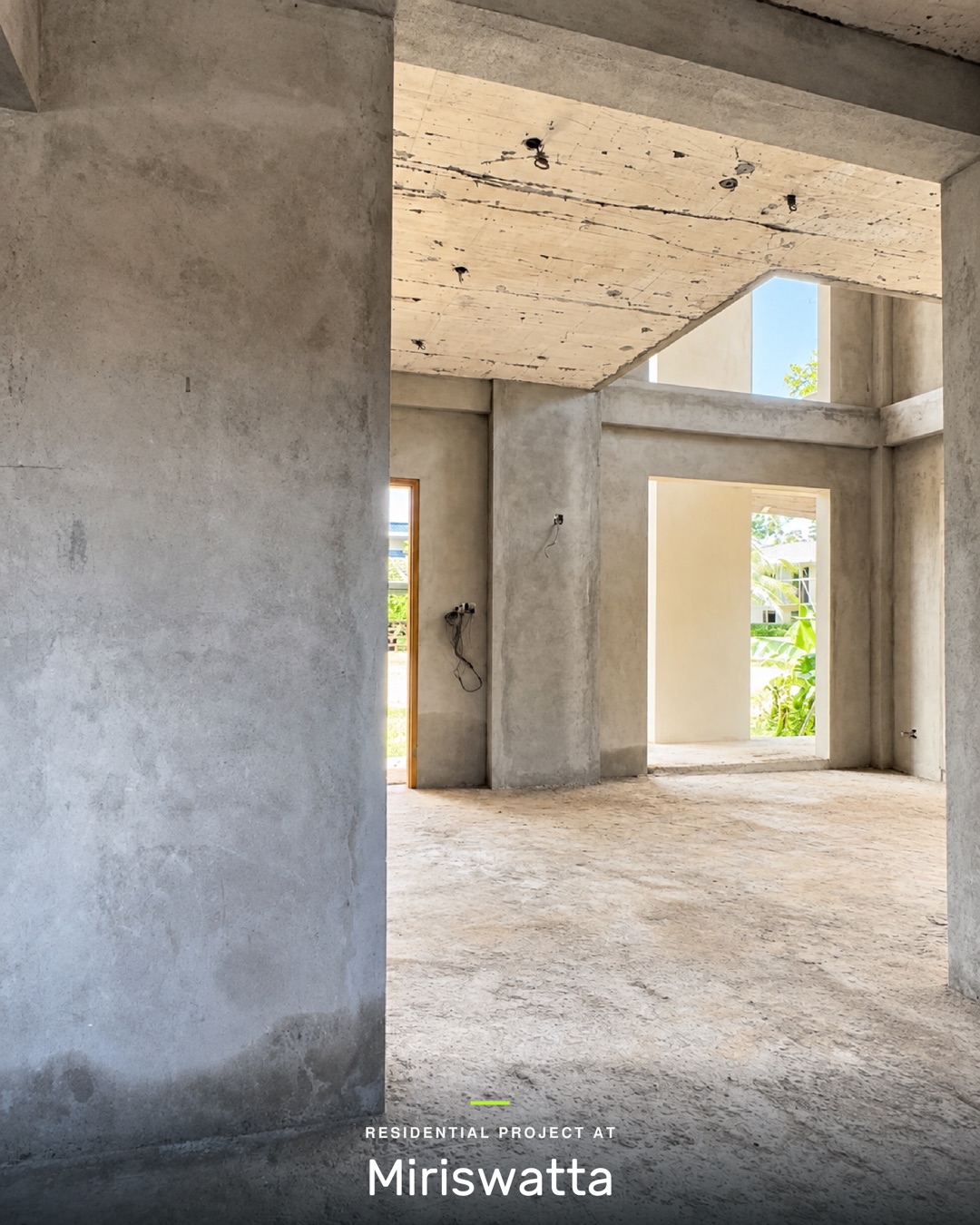 Ground floor living space with plastered walls and columns, open to the floor above